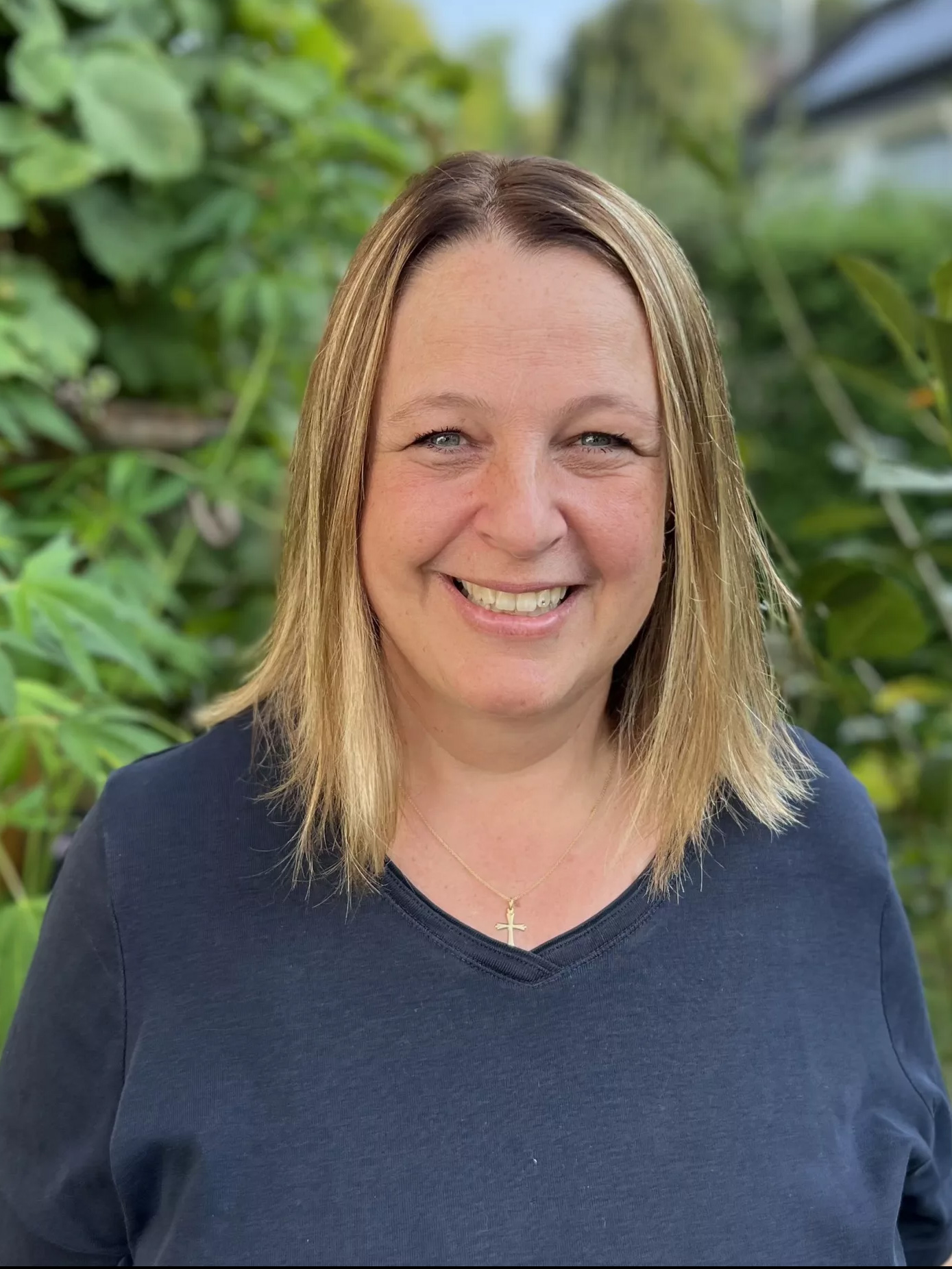 Portrait von Jana Kunst, freundlich lächelnd vor einem grünen Hintergrund.